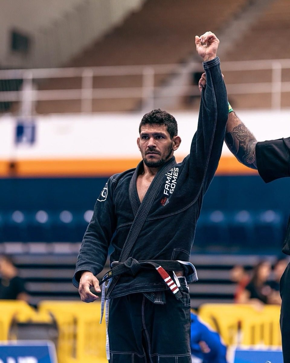 Coach with his hand raised after an IBJJF match