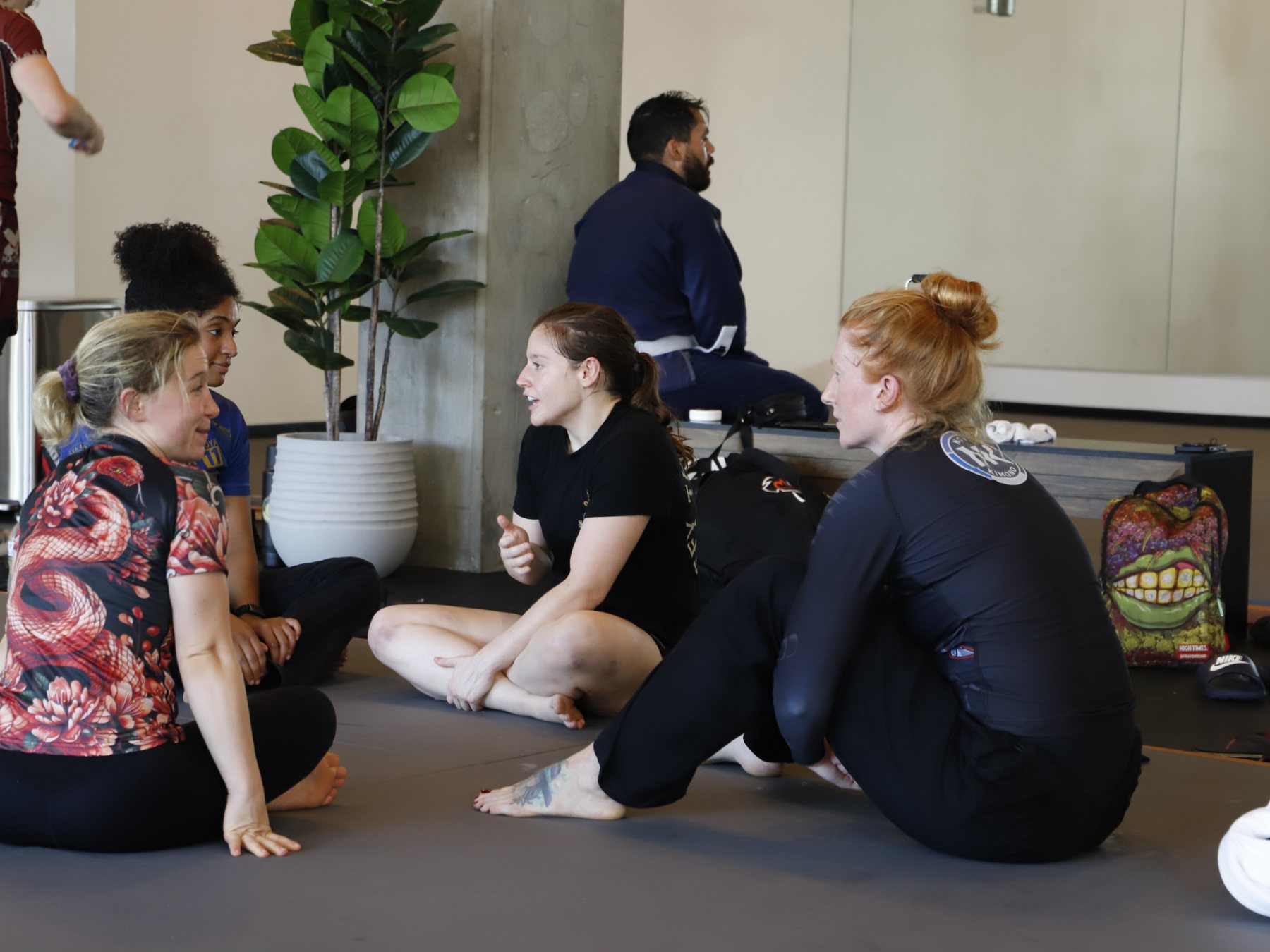 Women training partners talking on the mats between rounds